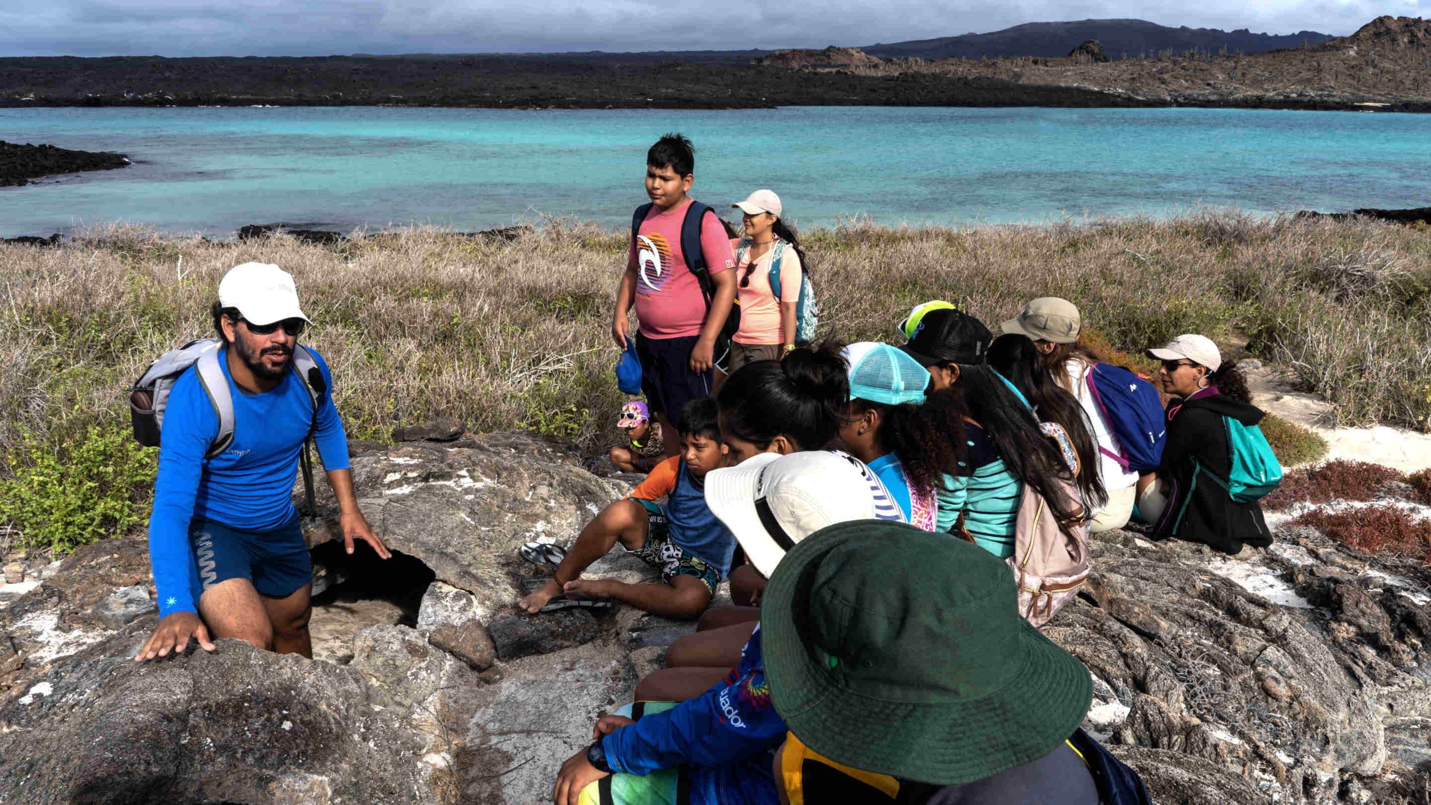 Un guía naturalista de Galápagos enseña a los alumnos de Naveducando en la isla del Sombrero Chino en Galápagos, Ecuador.